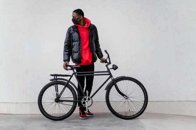 Side view afro-american man and his bicycle