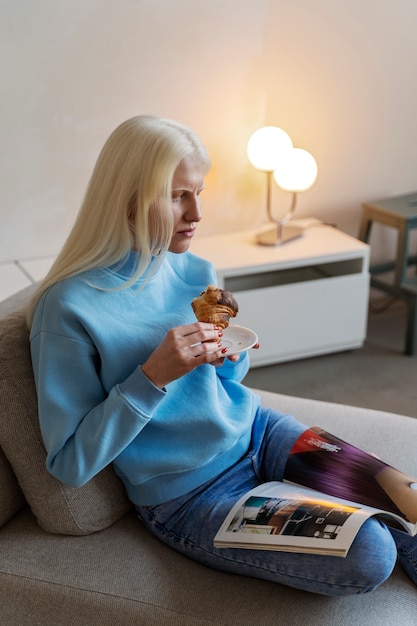 Free photo side view albino woman holding snack