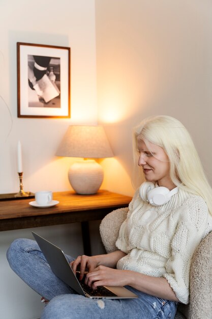 Side view albino woman working on laptop