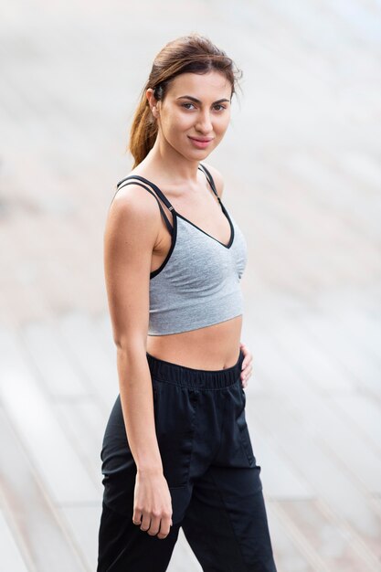 Side view of alluring woman posing outdoors while exercising