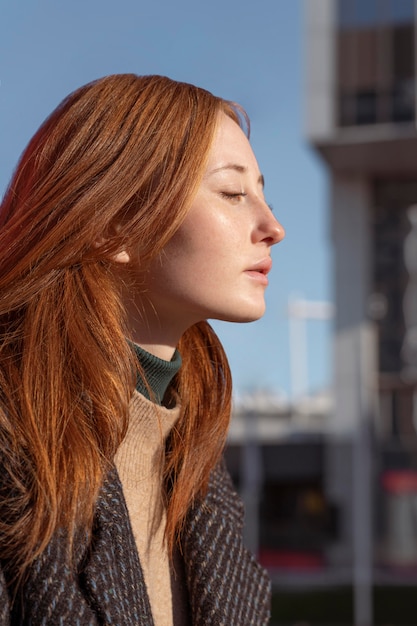 Side view of alluring woman posing outdoors