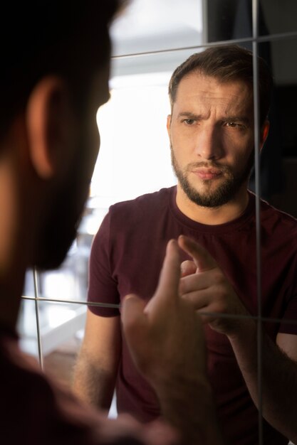 Side view anxious man looking in mirror