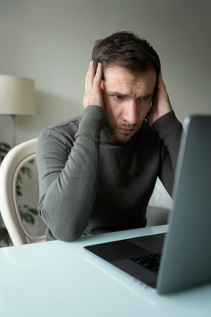 Side view anxious man with laptop