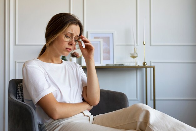 Donna ansiosa di vista laterale che si siede sulla sedia