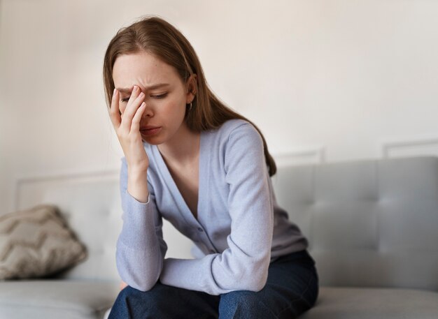 Side view anxious woman sitting at home