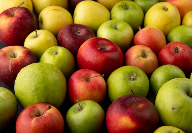 Вид сбоку яблочный микс зеленые желтые и красные яблоки фон