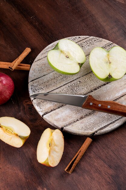 Side view apples sliced with knife on white board  vertical