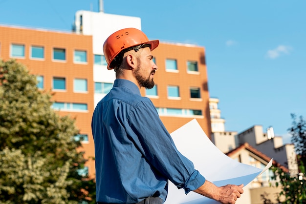 Side view of architect holding plans