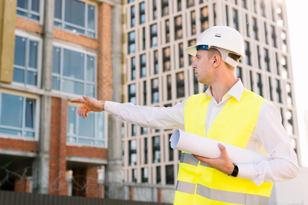 Side view architect pointing at building