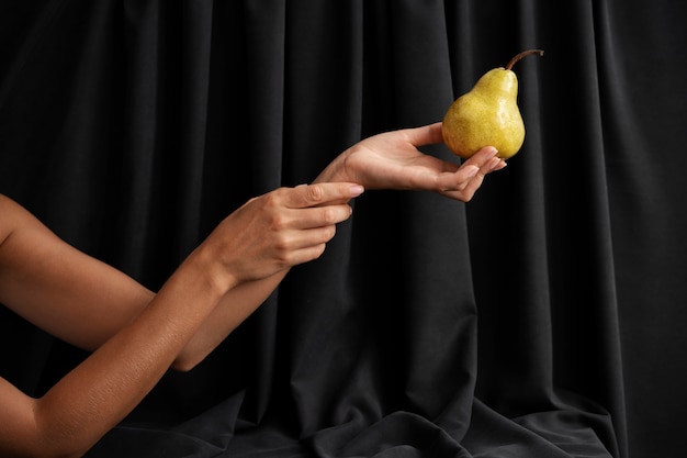 Free photo side view arms posing with pear