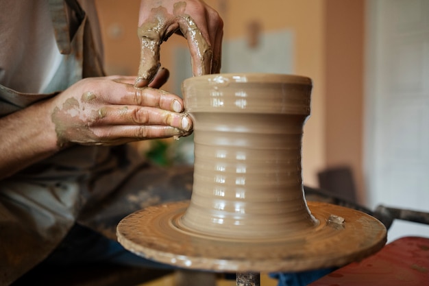 Free photo side view artisan doing pottery in studio