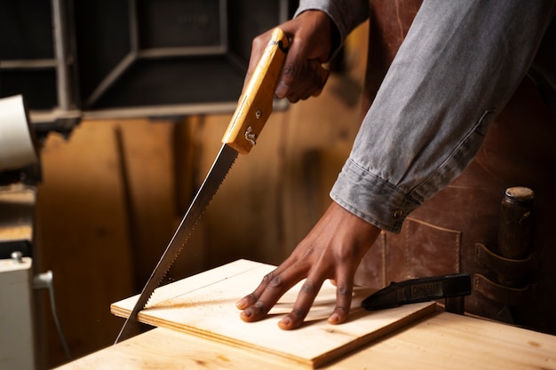 Free photo side view  artisan doing woodcutting