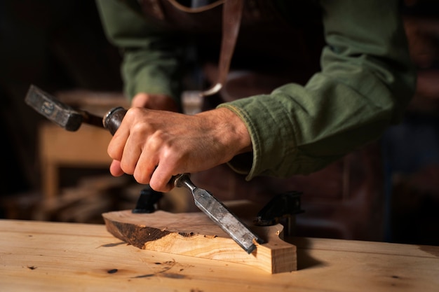 Free photo side view  artisan doing woodcutting