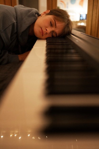 Free photo side view artist laying on piano