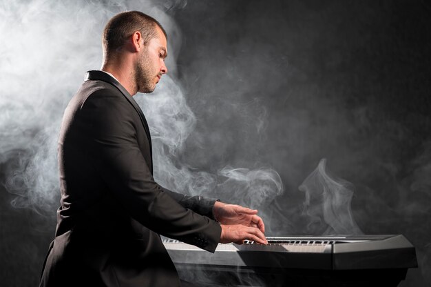 Бесплатное фото Вид сбоку артистический музыкант и эффект дыма