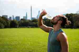 Free photo side view of athlete drinking water