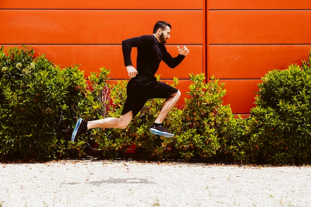 Free photo side view of a athlete performing a long jump