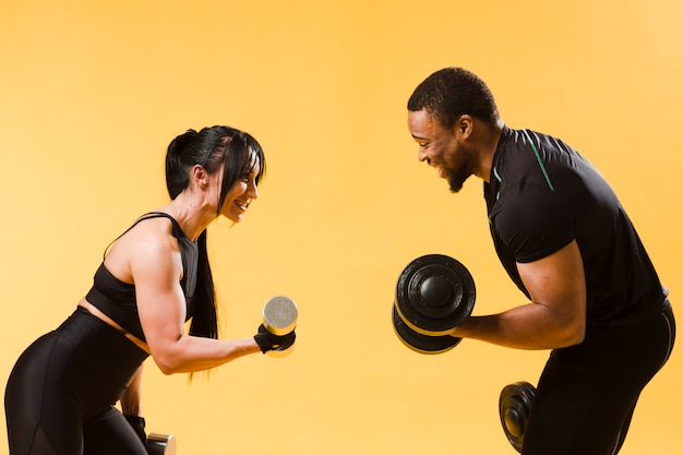 Side view of athletes holding weights