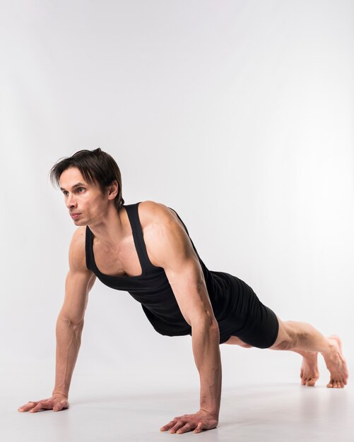 Side view of athletic man doing push ups