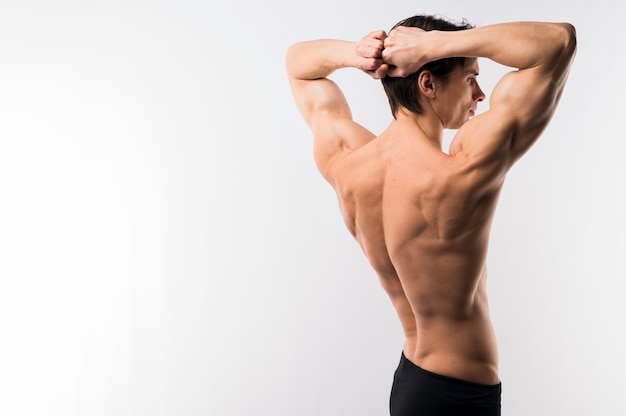 Free photo side view of athletic man showing off muscle body