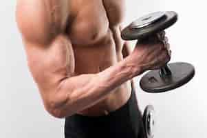 Free photo side view of athletic man torso holding weights