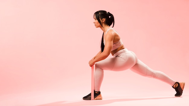 Side view of athletic woman doing lunges