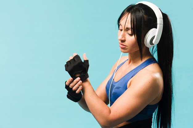 ヘッドフォンで体操服の運動女性の側面図