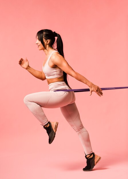 Side view of athletic woman with resistance band