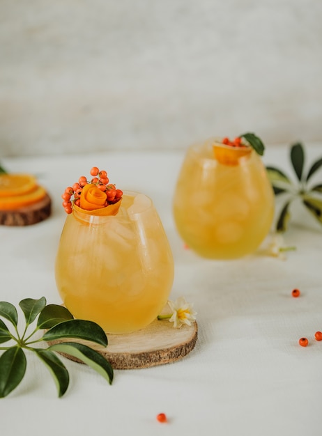 Side view of autumn cocktail with sea buckthorn and orange juice in a glasses on a table