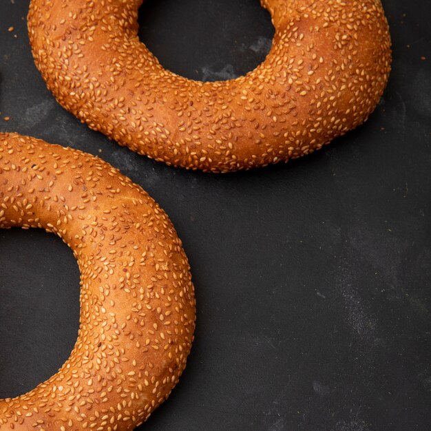 Side view of bagels on black background with copy space