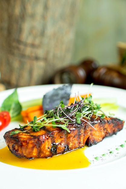 Side view of baked salmon with narsharab sauce on plate