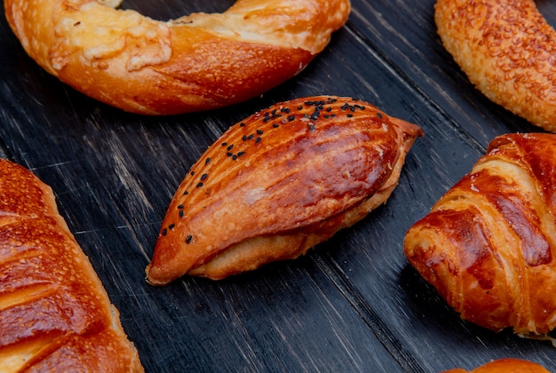 Side view of bakery products as roll bagel on wooden surface