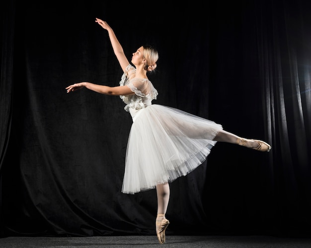 Side view of ballerina dancing in tutu dress