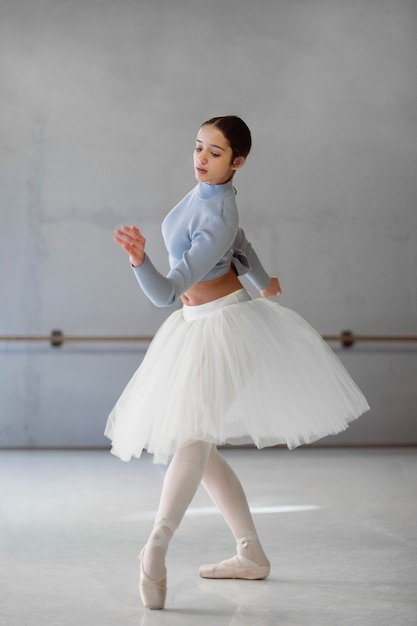 Side view of ballerina dancing  in tutu skirt and pointe shoes