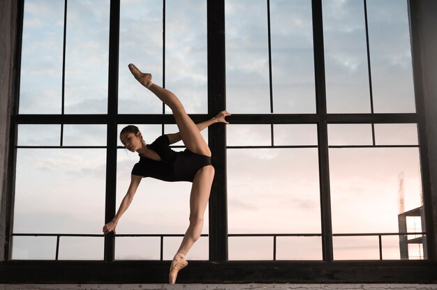 Side view of ballerina in leotard stretching