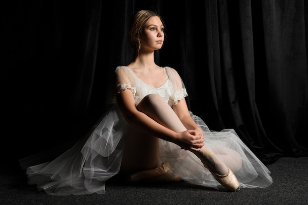 Side view of ballerina posing in tutu dress and pointe shoes