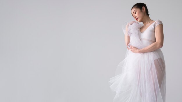 Side view of ballerina posing in tutu dress