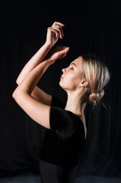Side view of ballerina posing with arms
