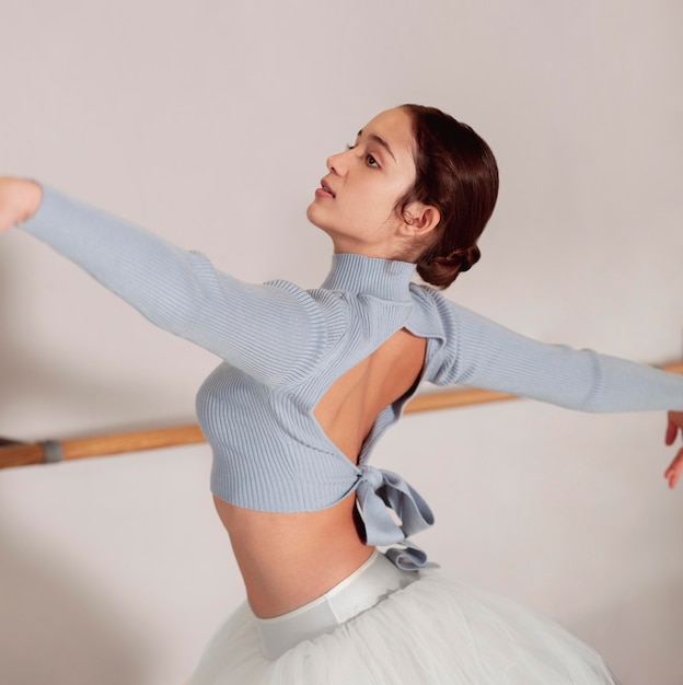 Side view of ballerina rehearsing in tutu skirt