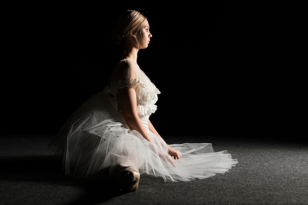 Side view of ballerina in tutu dress doing a split