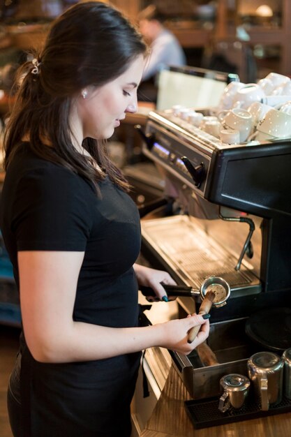 Side view barista using coffee machine