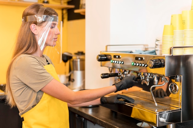 Side view barista wearing face protection