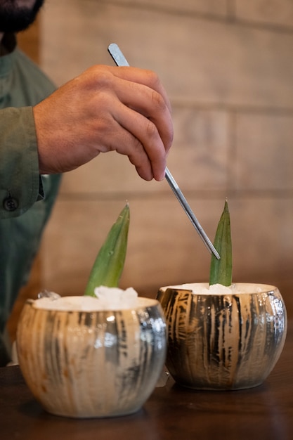 Free photo side view bartender making pina colada