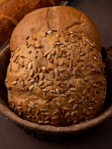 Side view of basket full of cob breads on maroon background