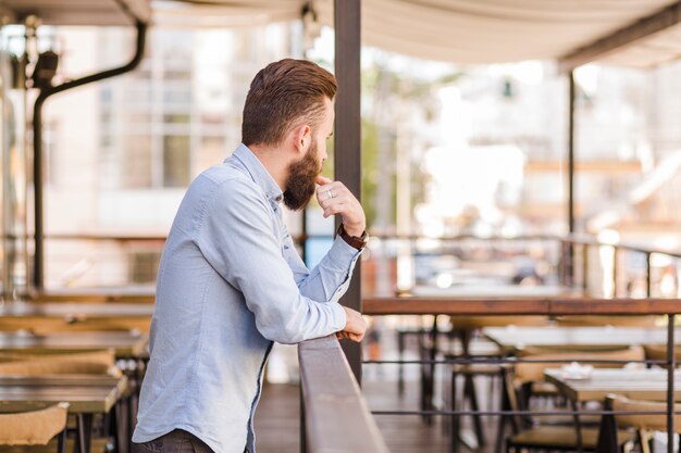 Side view of a bearded man standing in restaurant