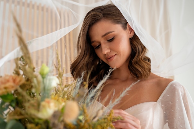 Free photo side view beautiful bride holding flowers