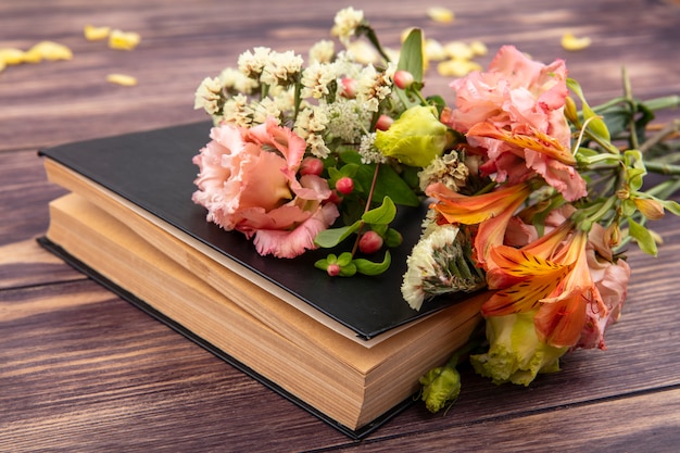 Side view of beautiful colorful and different flowers with leaves on a wooden surface