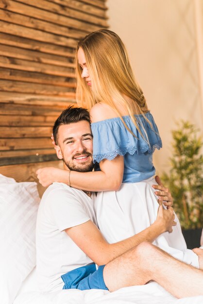 Side view of a beautiful couple embracing on bed