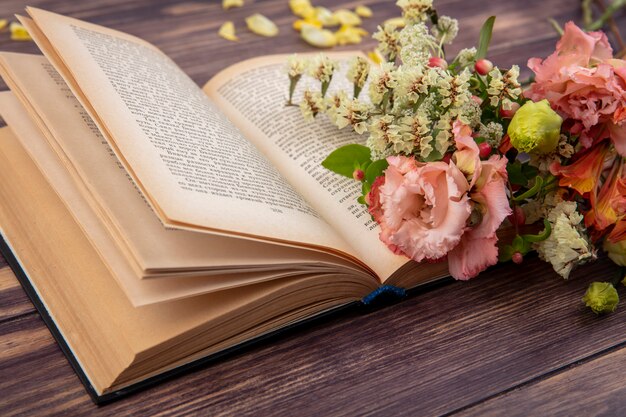 Side view of beautiful and different flowers on a wooden surface