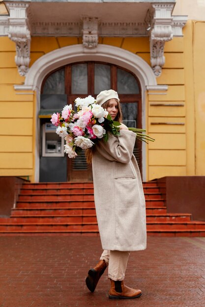 Side view of beautiful woman holding bouquet of flowers